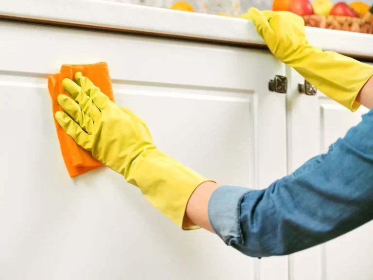 Wiping kitchen cabinets during an Airbnb clean in Apex, NC