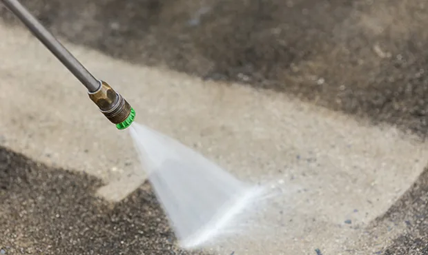 Pressure washing a stained concrete driveway in Raleigh, NC
