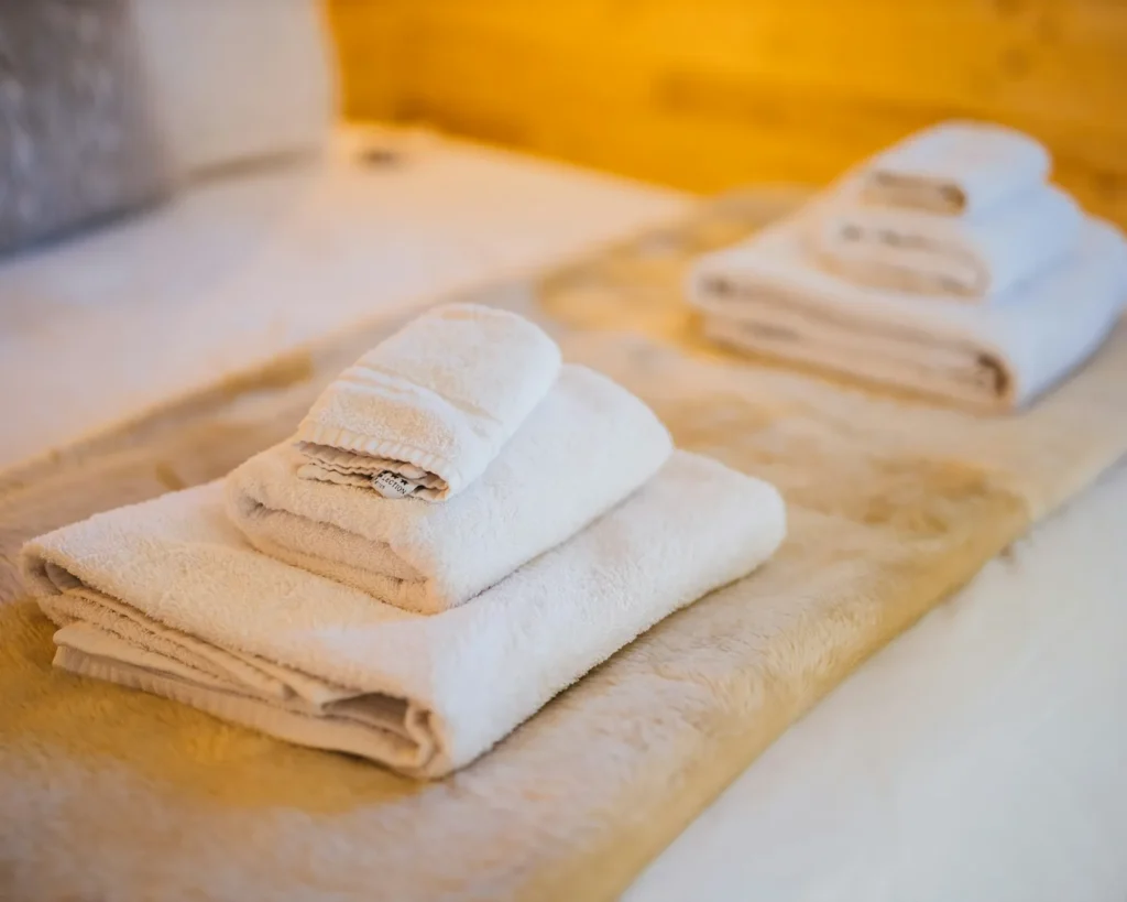 Fresh towels folded on the guest bed for the next Airbnb guest in Raleigh, NC