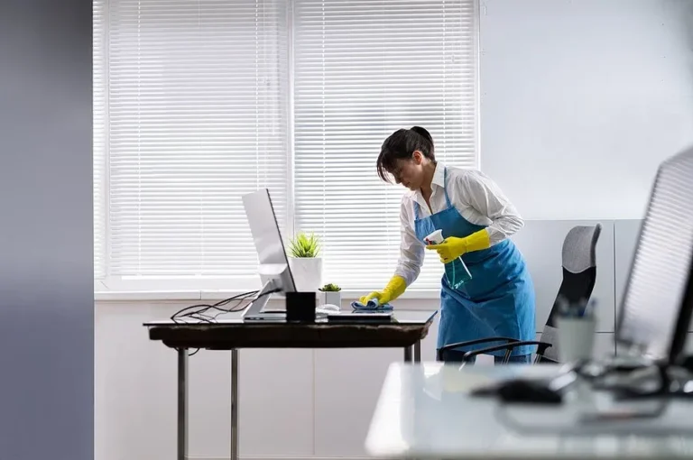 Cleaner wiping an office desk in Raleigh, NC